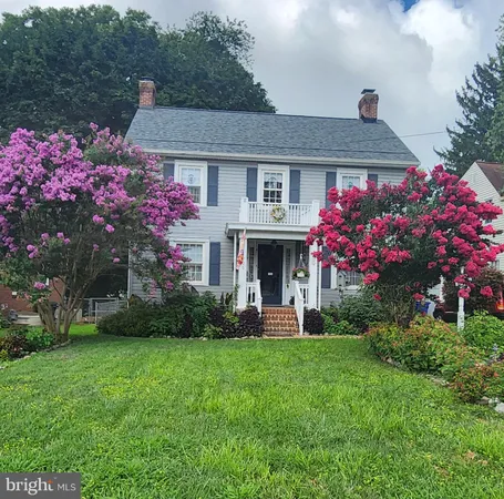 a front view of a house with a yard and fountain