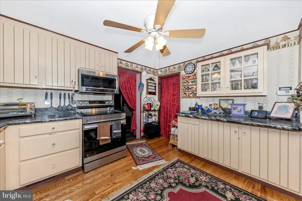 a kitchen with stainless steel appliances kitchen island granite countertop a refrigerator and a stove top oven