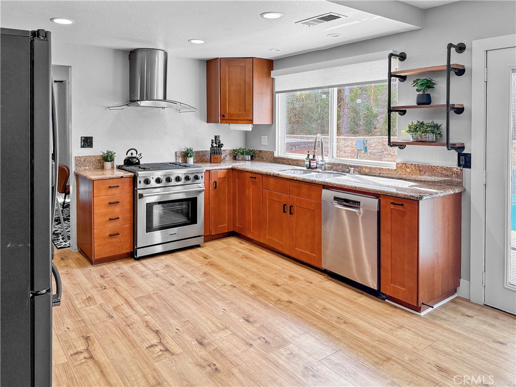 16955 Lake Knoll Parkway Riverside, CA 92503 - Photo 18 of 42 a kitchen with stainless steel appliances granite countertop a stove a sink and a refrigerator