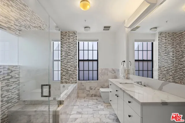 a large white bed sitting in a room next to a window