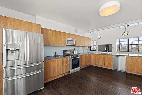 a kitchen with wooden floors and appliances