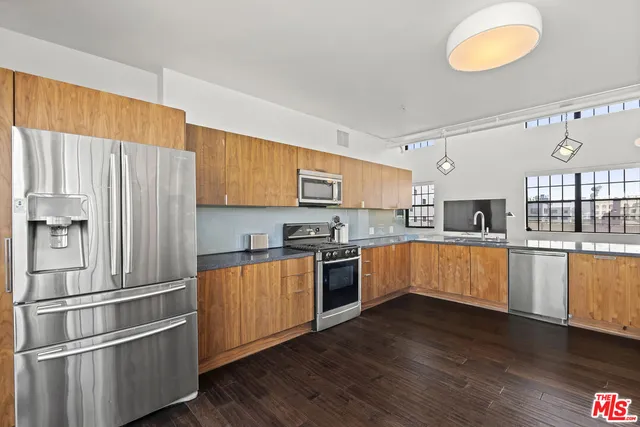 a kitchen with wooden floors and appliances