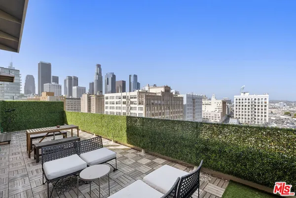 a view of a city from a patio with chairs