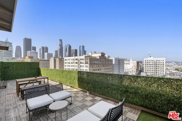 a view of a city from a patio with chairs