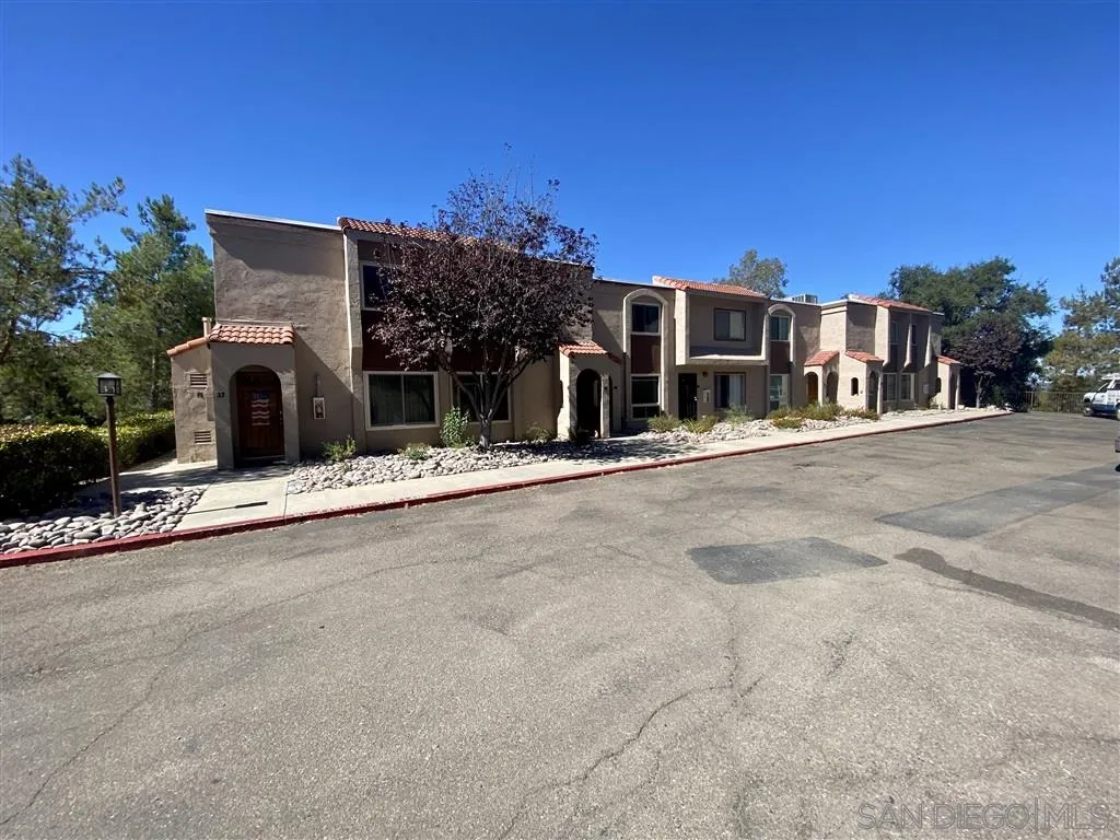 a view of a house with a road and a building
