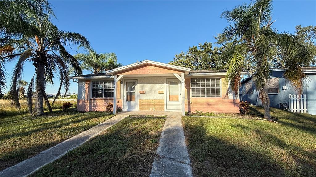 12611 1st Isle Hudson, FL 34667 - Photo 1 of 19 a front view of a house with a garden and trees