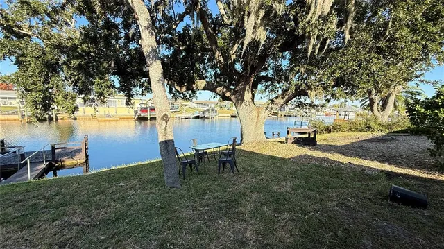 a view of a backyard with table and chairs and couches with wooden fence