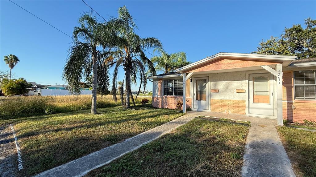 12611 1st Isle Hudson, FL 34667 - Photo 2 of 19 a front view of a house with a garden and patio