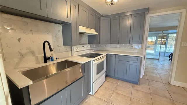 a kitchen with a sink and a stove top oven