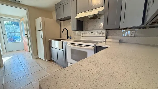 a kitchen with stainless steel appliances a stove a sink and a refrigerator