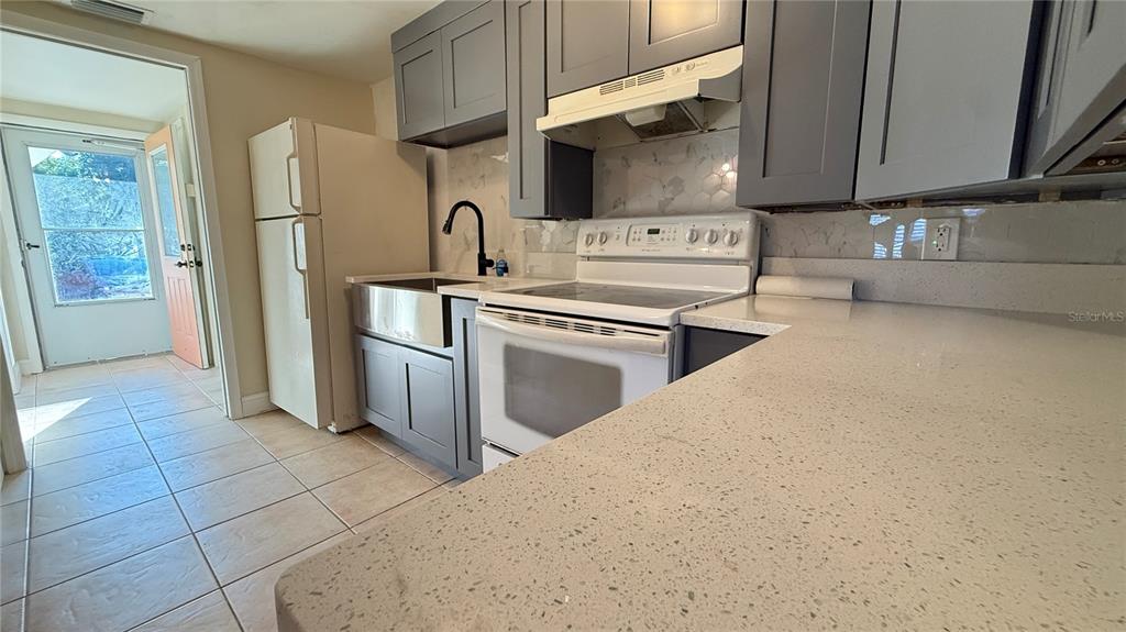 12611 1st Isle Hudson, FL 34667 - Photo 9 of 19 a kitchen with stainless steel appliances a stove a sink and a refrigerator
