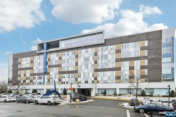 a front view of a building with cars parked
