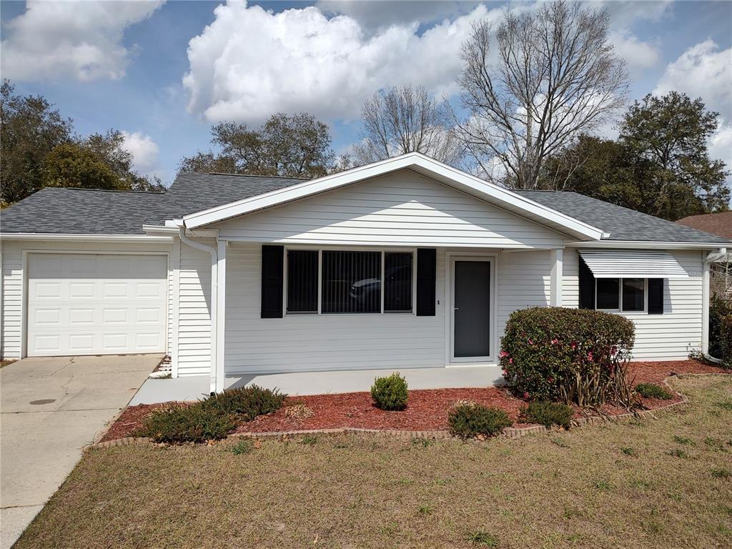 8435 Southwest 109th Lane Ocala, FL 34481 - Photo 1 of 28 a front view of a house with garden