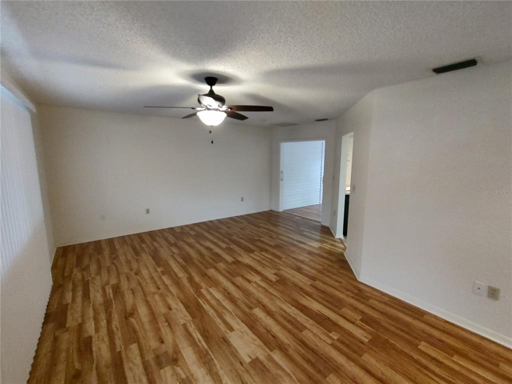 8435 Southwest 109th Lane Ocala, FL 34481 - Photo 6 of 28 a view of a room with wooden floor and ceiling fan