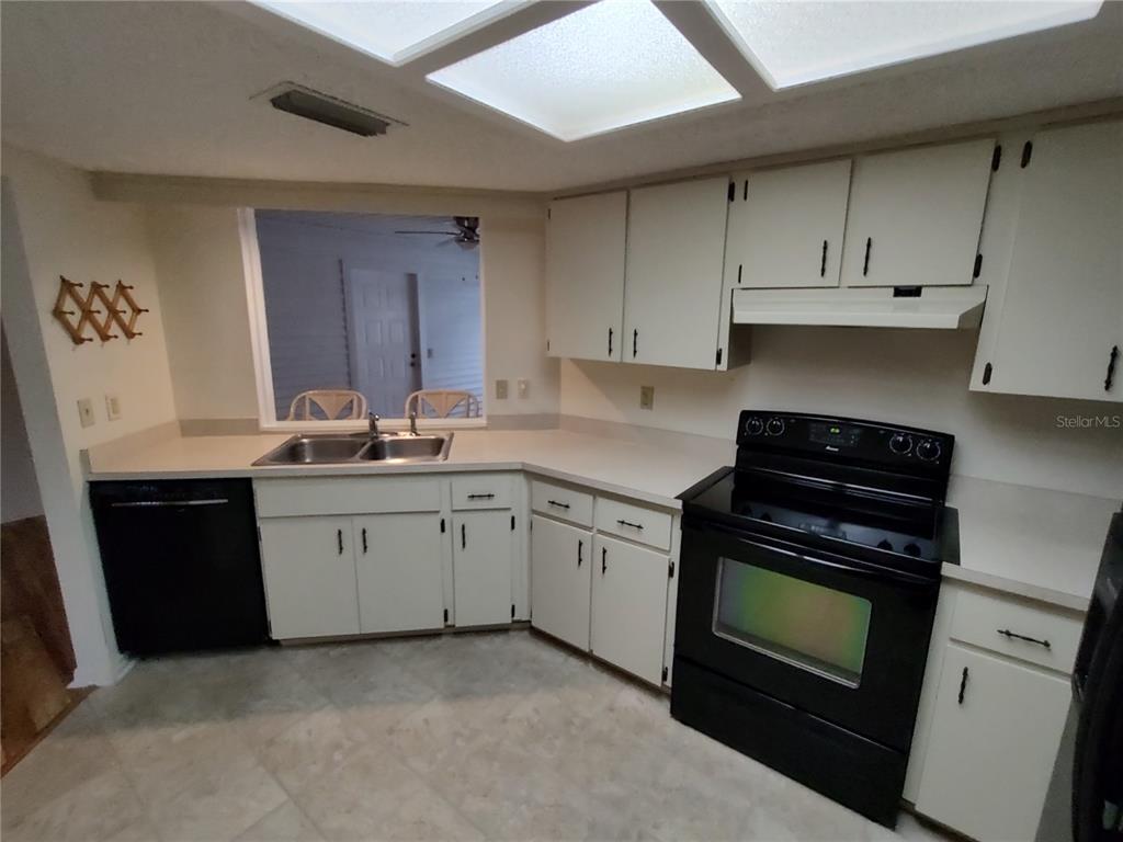8435 Southwest 109th Lane Ocala, FL 34481 - Photo 8 of 28 a kitchen with granite countertop a sink a stove and cabinets