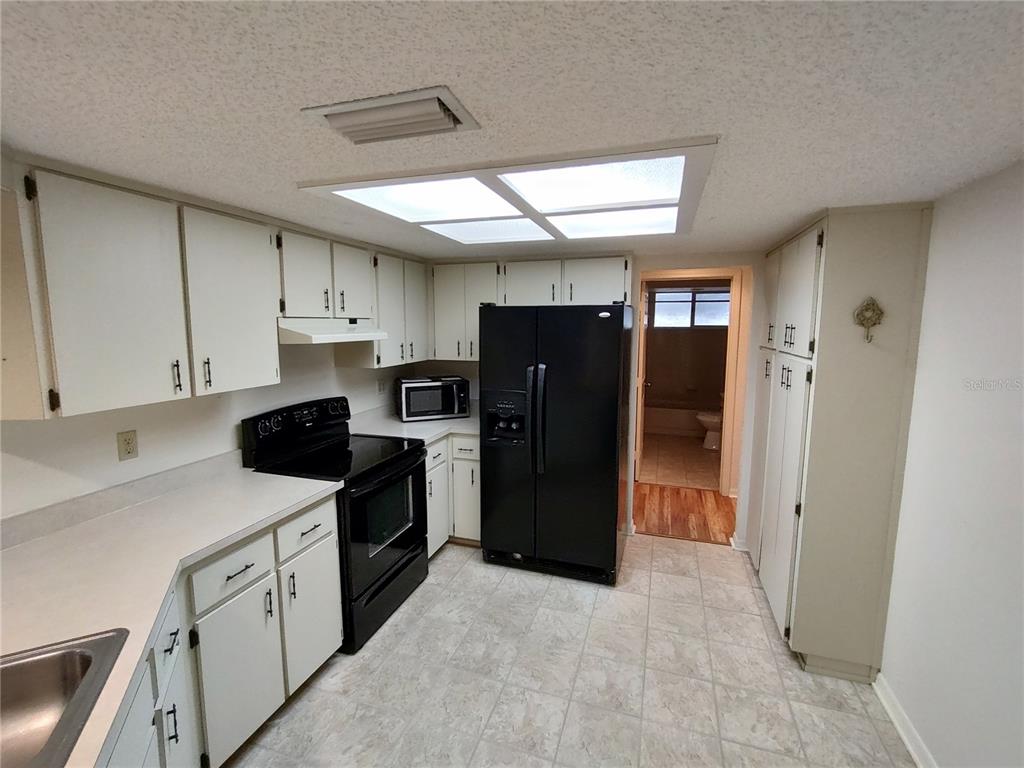 8435 Southwest 109th Lane Ocala, FL 34481 - Photo 10 of 28 a kitchen with a refrigerator and a sink