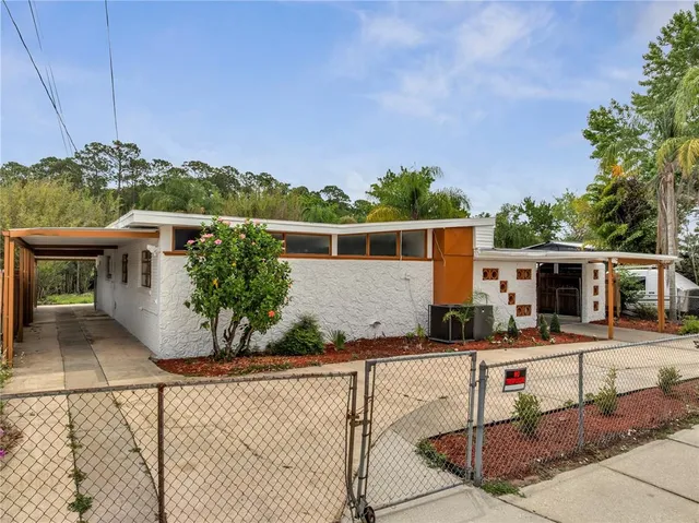 a view of a house with backyard and sitting area