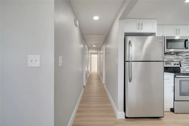 a view of a hallway with wooden floor