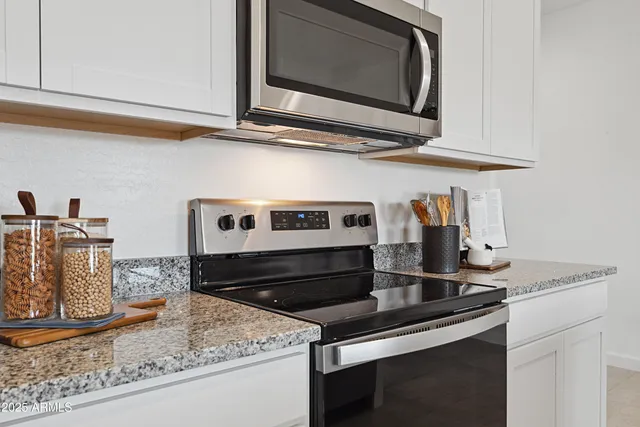 a kitchen with stainless steel appliances granite countertop a sink stove and microwave