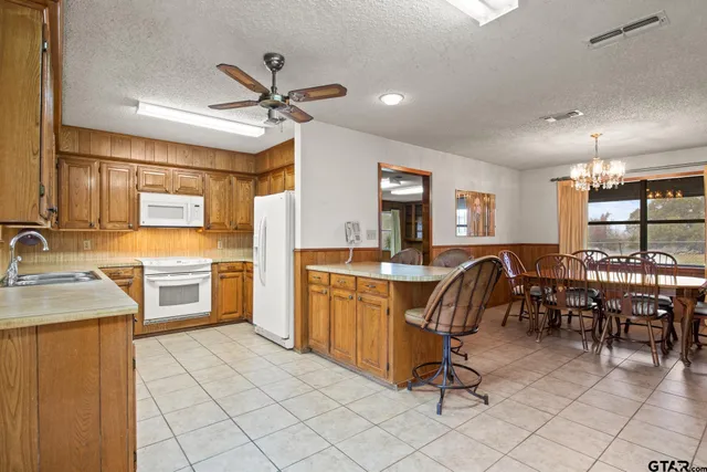a dining room with furniture a chandelier and window
