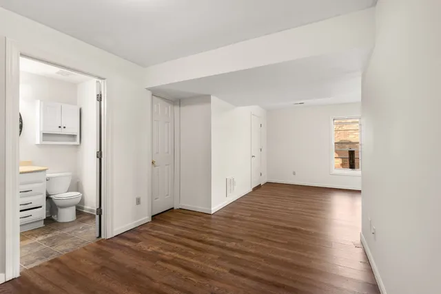 a view of a room with wooden floor and a bathroom view