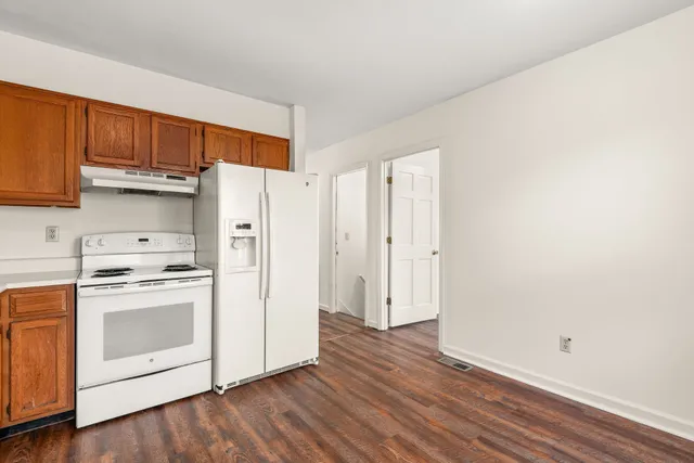 a kitchen with a white cabinets and wooden floor