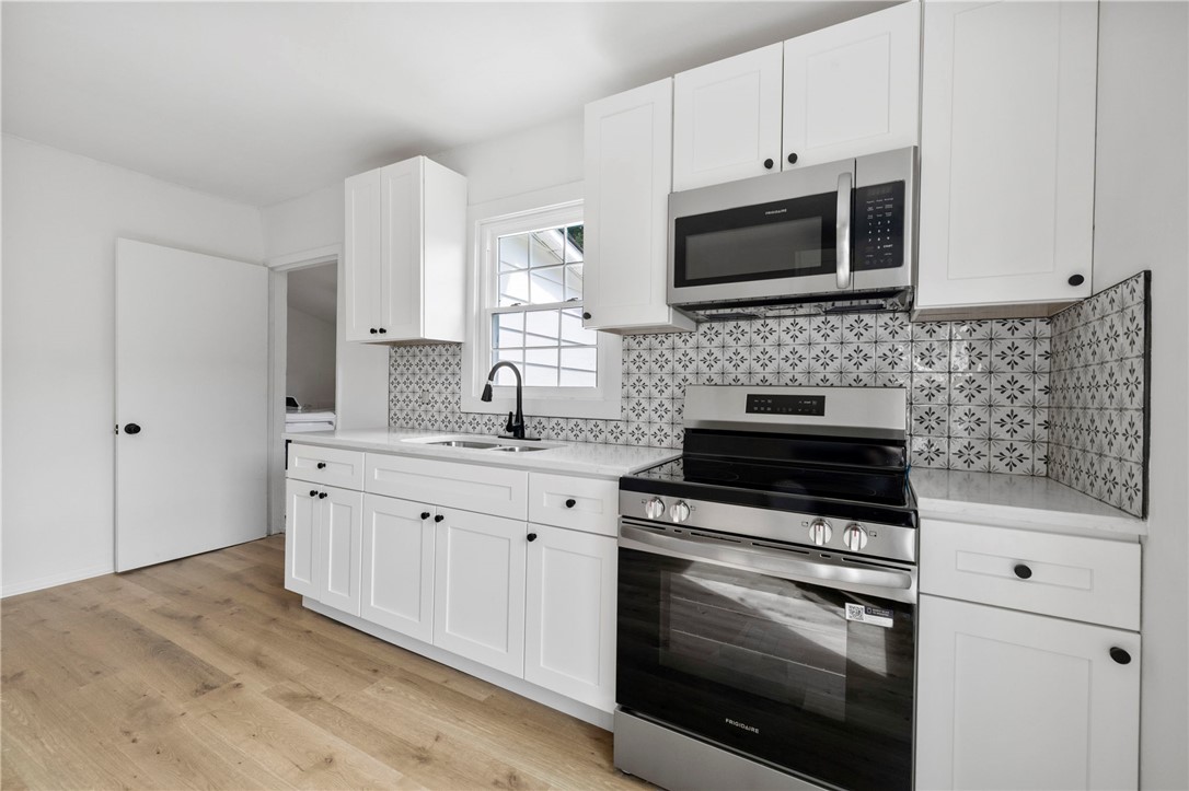 201 South 8th Street Easley, SC 29640 - Photo 10 of 28 Crisp cabinetry and patterned tile details define this freshly updated kitchen workspace.