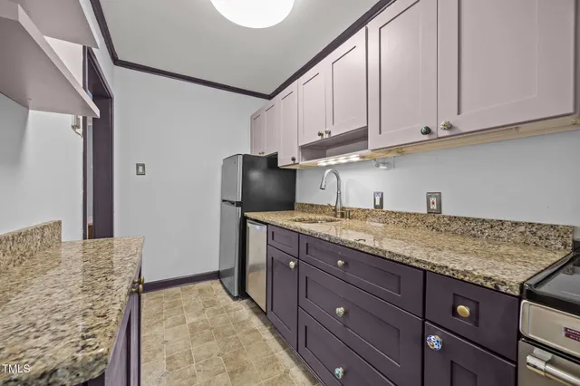 a kitchen with a refrigerator sink and cabinets