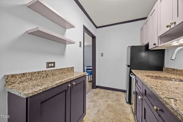 a kitchen with granite countertop cabinets and refrigerator