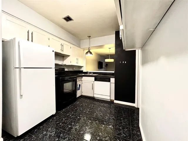 a kitchen with a refrigerator and a stove