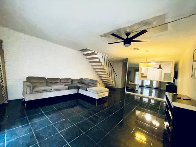 a living room with a couch and a potted plant