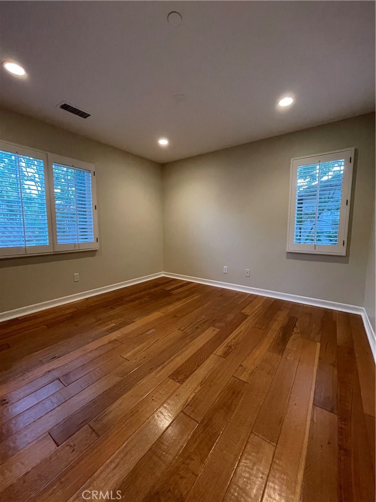 20 Arborside Irvine, CA 92603 - Photo 27 of 36 an empty room with wooden floor and windows