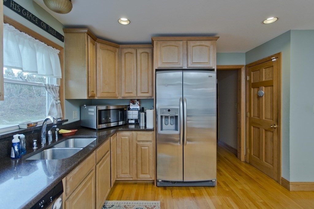 860 Plumtree Road Springfield, MA 01109 - Photo 16 of 21 a kitchen with stainless steel appliances granite countertop a refrigerator a stove and a sink with wooden floor