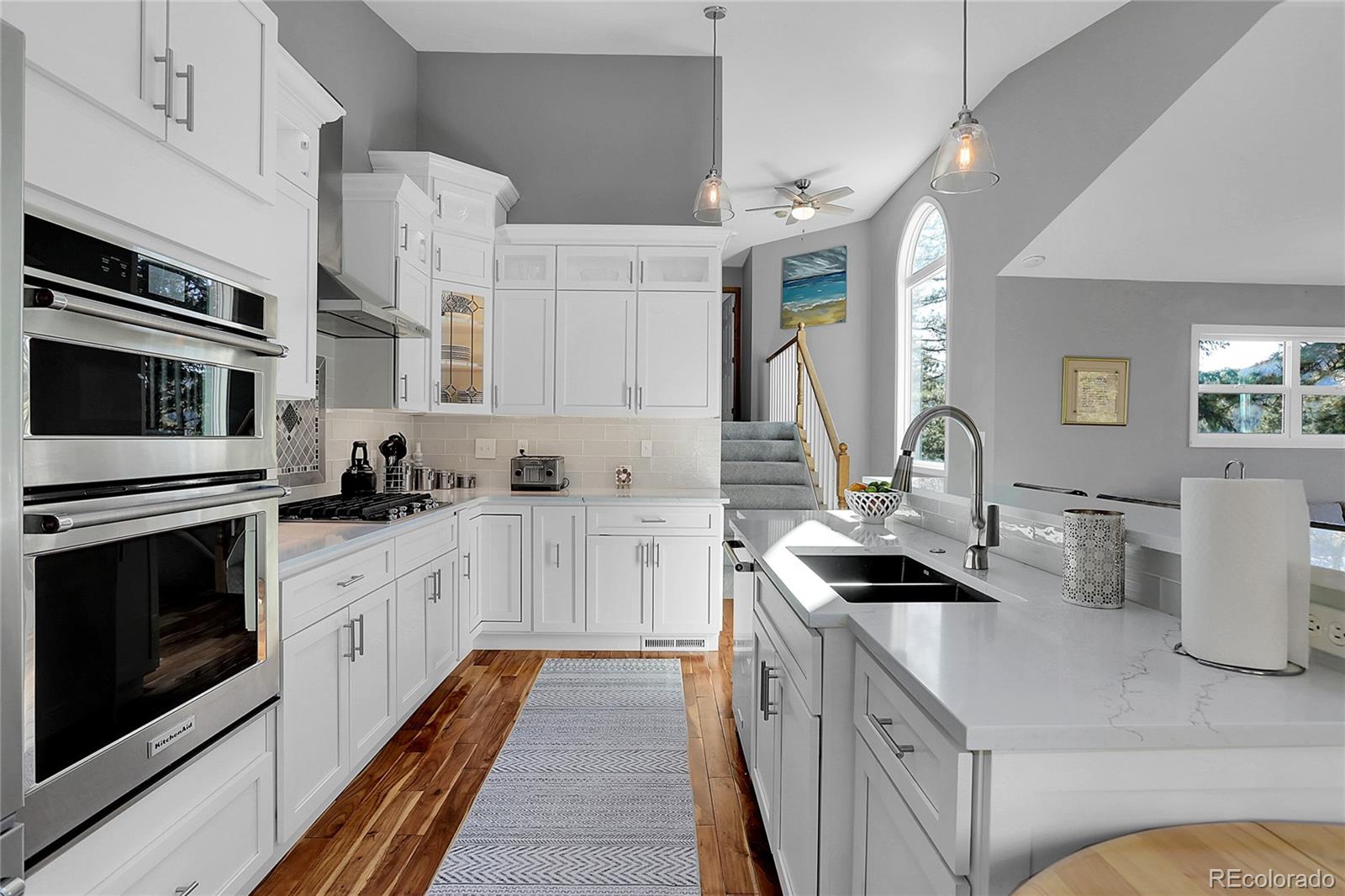 32857 Little Cub Road Evergreen, CO 80439 - Photo 14 of 48 a kitchen with stainless steel appliances granite countertop a stove a sink and a microwave
