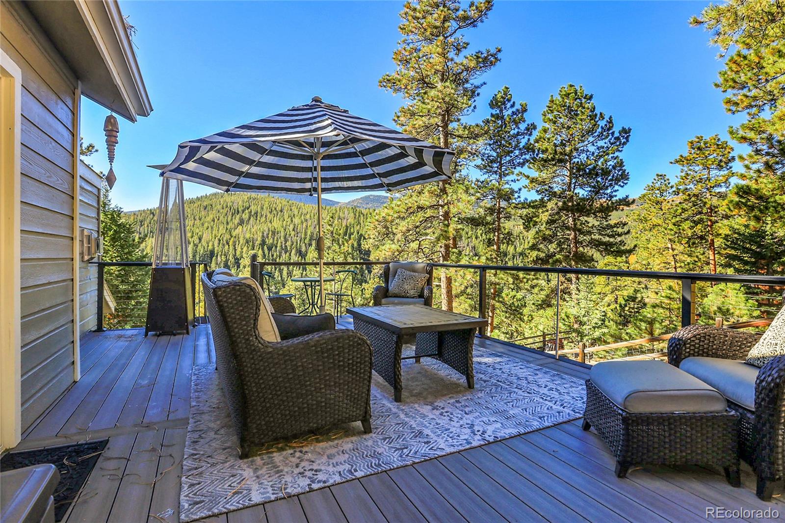 32857 Little Cub Road Evergreen, CO 80439 - Photo 19 of 48 a balcony with wooden floor and outdoor seating