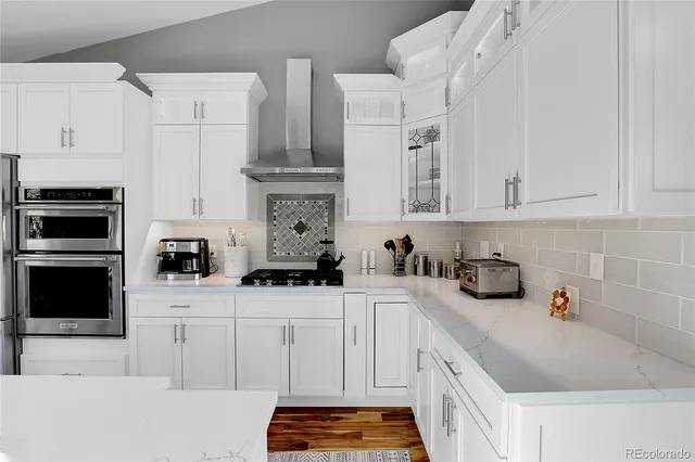 a kitchen with white cabinets and appliances