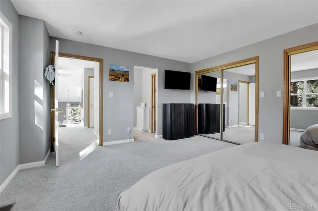 a large bedroom with a bed and a television