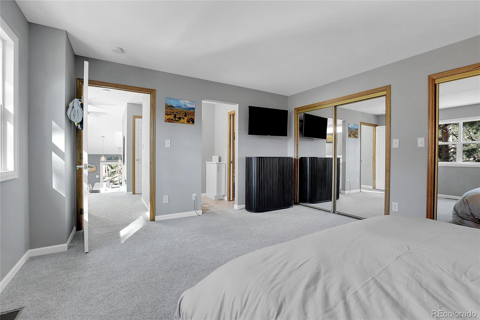 32857 Little Cub Road Evergreen, CO 80439 - Photo 32 of 48 a large bedroom with a bed and a television