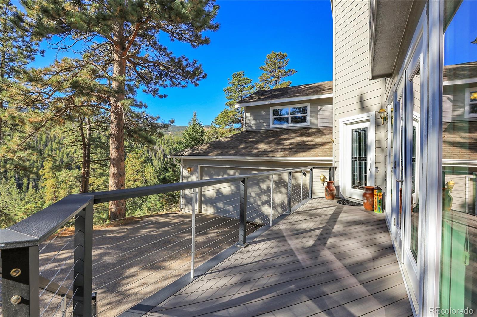 32857 Little Cub Road Evergreen, CO 80439 - Photo 5 of 48 a view of a balcony with chairs and a potted plant
