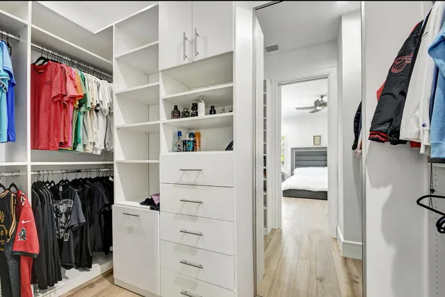 a view of walk in closet with clothes and shoes