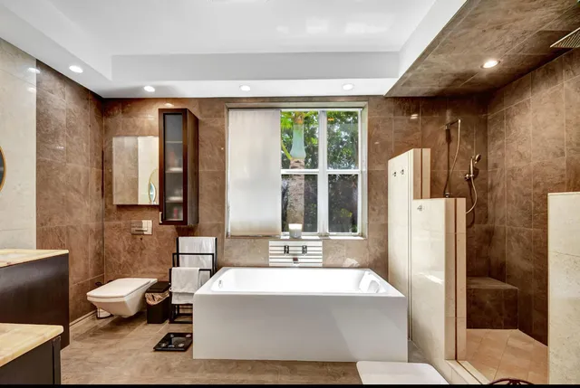 a spacious bathroom with a large tub shower and sink