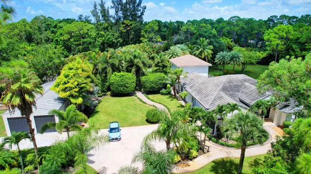 an aerial view of a house with a yard and green space