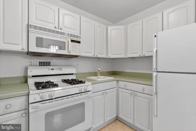 a kitchen with cabinets appliances and a counter space
