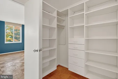 a view of walk in closet with empty racks