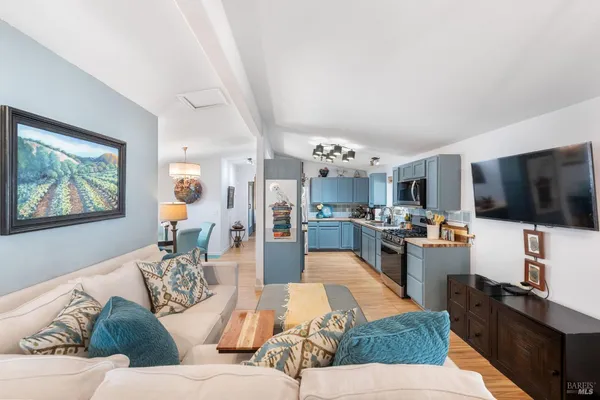 a living room with furniture kitchen view and a window