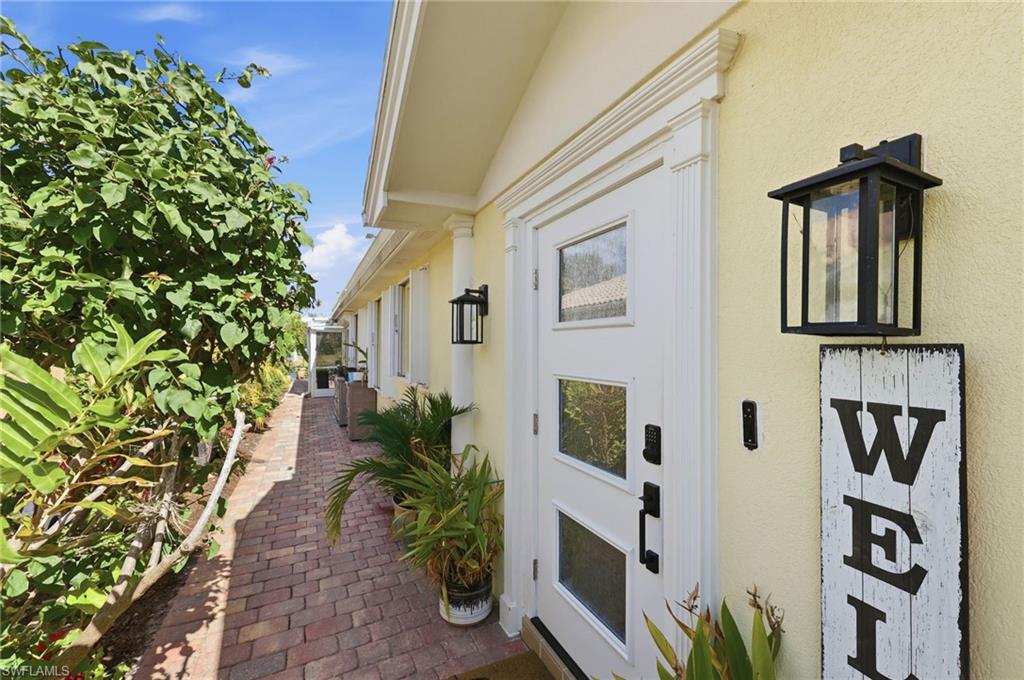 7575 Novara Court Naples, FL 34114 - Photo 4 of 49 Custom Front entry Door and keypad lock system. Accordion Storm Shutters on every window