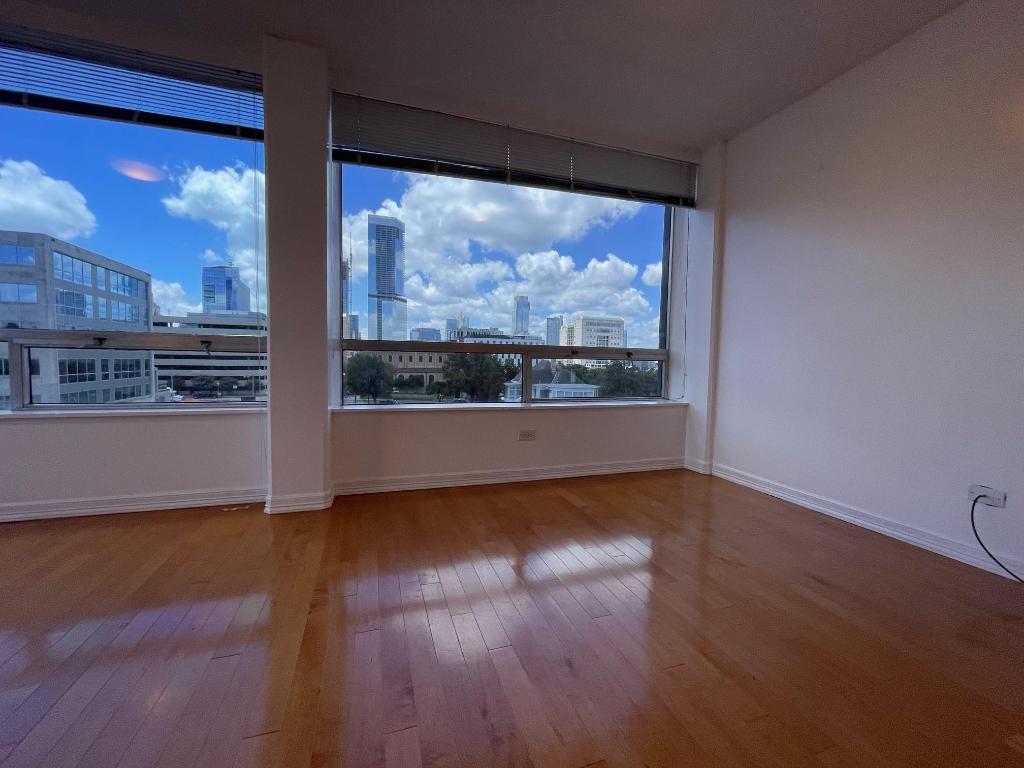 Spare room with a skyline view and wood-type flooring