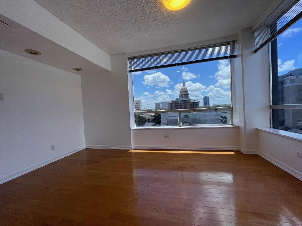 1212 Guadalupe Street, Unit 601 Austin, TX 78701 - Photo 3 of 5 Spare room featuring a view of city, dark wood-style flooring, and a textured ceiling