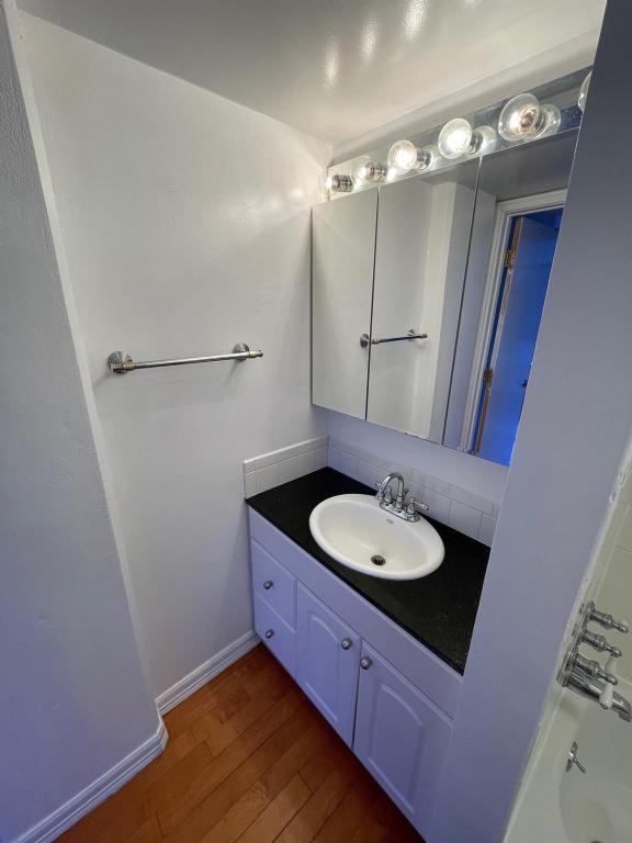 1212 Guadalupe Street, Unit 601 Austin, TX 78701 - Photo 4 of 5 Full bath with dark wood-style floors, vanity, and washtub / shower combination