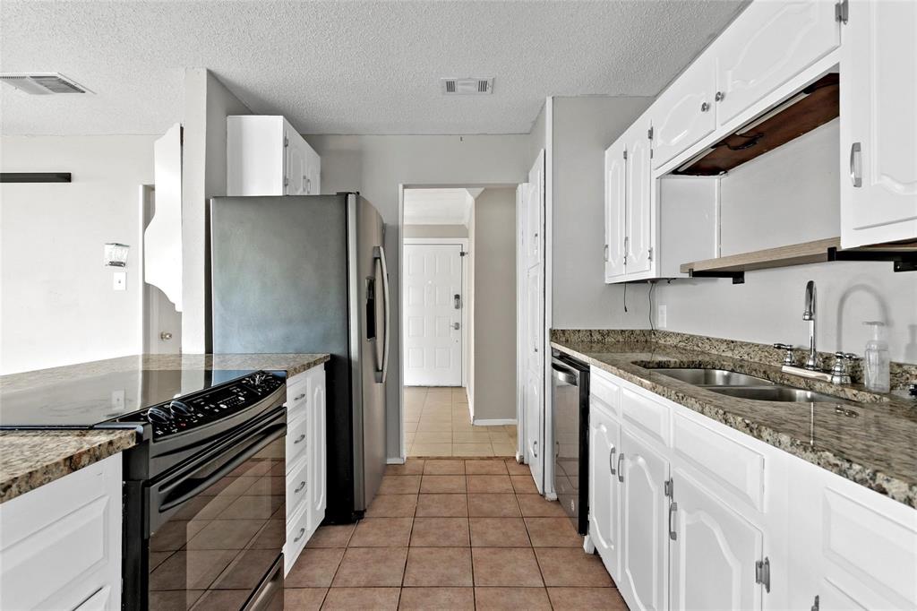 6104 Kelly Elliott Road Arlington, TX 76001 - Photo 15 of 25 a kitchen with granite countertop a sink stove and refrigerator